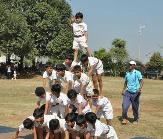 A group of young boys stands triumphantly atop a pyramid, showcasing their excitement and camaraderie.